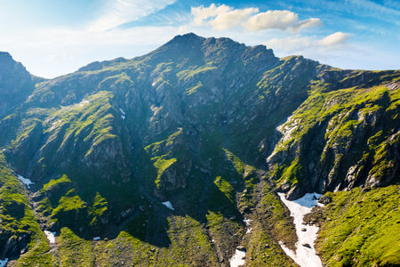 romania mountain landscape in summer. fagaras ridge on a sunny day under blue sky with clouds. alpine scenery with rocky peaks and steep slopes. horizontal travel background of scenic place for hikingの写真素材
