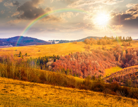 countryside mountain landscape in autumn at sunset. alps in evening light. beautiful place. scenery with forest on rolling hills. beauty in nature and rural sustainability conceptの写真素材