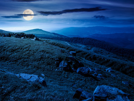 alpine meadows in mountains in summer at night. stones on grassy hills in full moon light. popular travel destination for photo. beautiful placeの写真素材