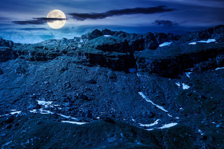 mountain landscape in summer at night. alpine scenery with rocky peaks and steep slopes.