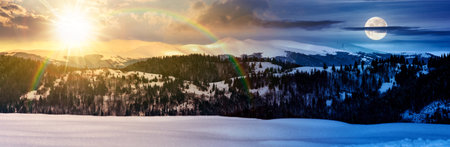 panorama of mountain ridge in winter. day and night time change concept. magnificent alpine landscape with snowy peaks with cloudy sky with sun and moon at twilight.の写真素材