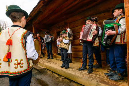 uzhhorod, ukraine - 13 jan, 2018: hutsuls singing christmas carols outdoor. folk music festival during winter holiday of ts. basil. group of children in traditional closes having funのeditorial素材