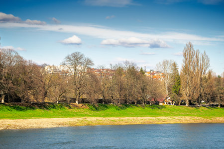 uzhhorod, ukraine - 14 mar 2016: river uzh on a sunny weather. ukrainian city embankment in spring. urban landscape of eastern europe with part of masaryk bridgeのeditorial素材
