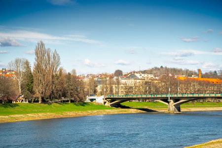 uzhhorod, ukraine - 14 mar 2016: river uzh on a sunny weather. ukrainian city embankment in spring. urban landscape of eastern europe with masaryk bridge over the waterのeditorial素材