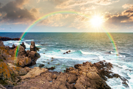 sunset over beautiful rocky sea shore. blue waves crashing the beach. coastal landscape with clouds...