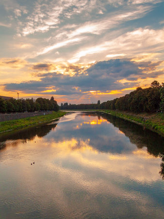 uzhhorod, ukraine - 31 jun, 2007: view of the river uzh at sunset. lush trees on the grassy shore in...