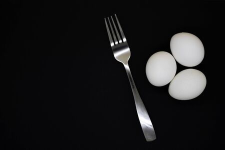 Unprepared white chicken egg on a black backgroundの写真素材