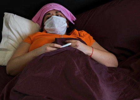 Woman who is sick with coronavirus and constantly measures the temperatureの写真素材
