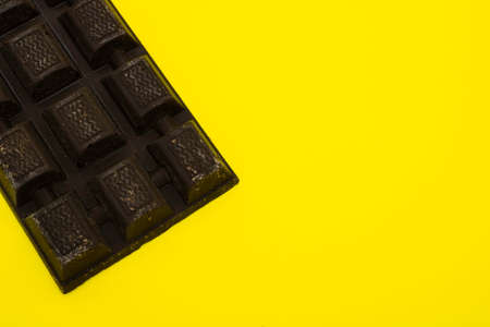 Dark chocolate bar on a yellow backgroundの写真素材