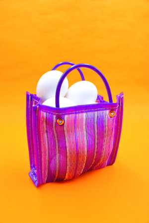 Bag to go to the market, sent or super Mexican style, with white eggs inside, on an orange backgroundの写真素材
