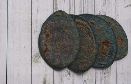 Tlacoyo on a white napkin with blue edges, on a wooden board