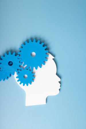 Silhouette of a human head with gears on a blue background