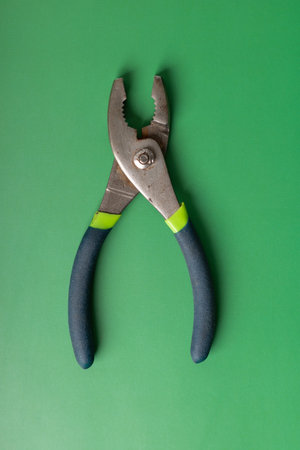 Pliers on a green background, close-up, top view