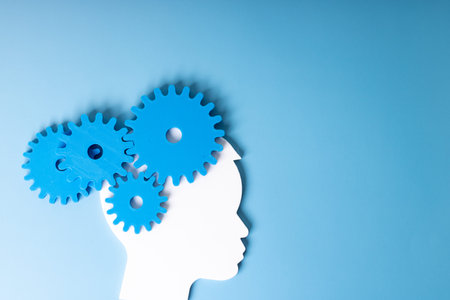Silhouette of a human head with gears on a blue backgroundの写真素材