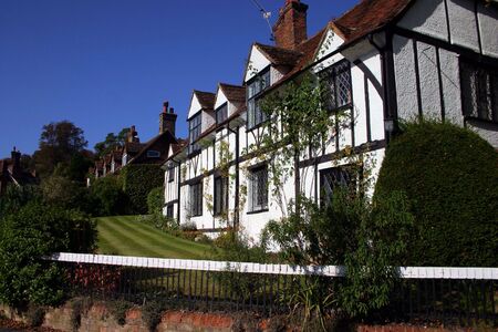 Whitewashed timbered cottages with manicured lawns form a pretty rural village scene at Latimer Buckinghamshire Englandの写真素材