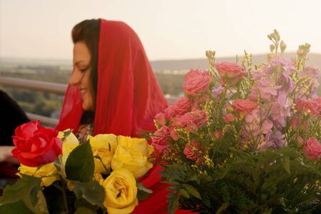 Woman at Balcony with Flowers in Foregroundの写真素材