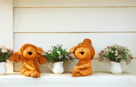 Clay doll and flower in ornamental gardenの写真素材