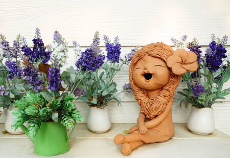Clay doll and flower in ornamental gardenの写真素材
