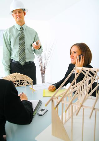 successful contractor about to presenting his work to two business women on tableの写真素材