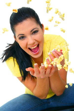 close up shot of young woman excited and throwing popcorn up in the airの写真素材