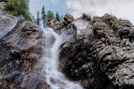 The waterfall is close up, the water falls and flows down the rocks.