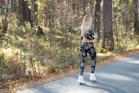 Athletic girl running in the park in the afternoon.の写真素材