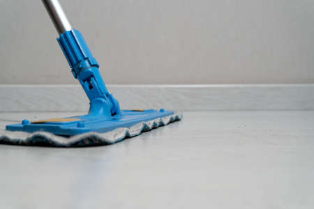 Close-up of a mop wiping the floor.