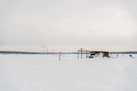 Abandoned building on the background of a snowy field.の写真素材