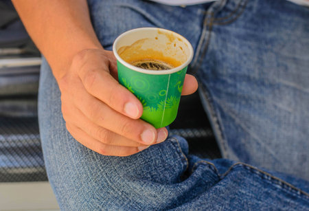 man holding green cup coffee, selective focus point.