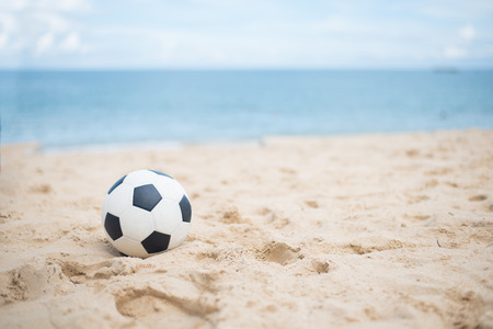 Soccer ball on sandy beach after gameの写真素材
