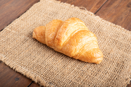 freshly baked croissant on wooden tableの写真素材