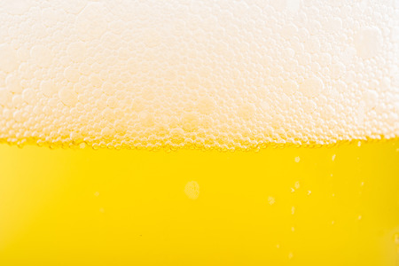 Pouring beer with bubble froth in glass for background