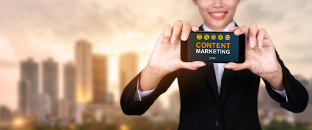 Content marketing concept, Happy businesswoman Show text Content marketing on Smart Phone.の写真素材