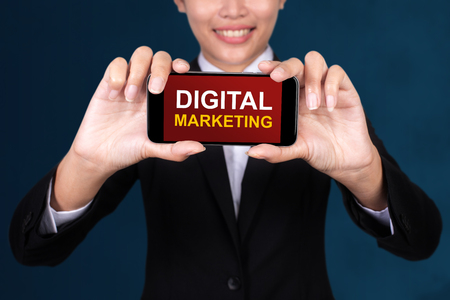 Digital marketing concept, Happy businesswoman Show text Digital marketing on Smart Phone.の写真素材