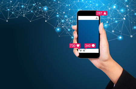 Social Media concept. Communication in social networks. Image of mobile phone with message icons, likes and subscribers.の写真素材
