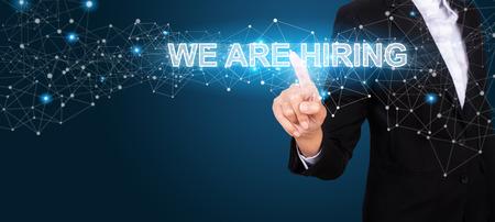 WE ARE HIRING concept with Hand of business pressing a button WE ARE HIRING.の写真素材
