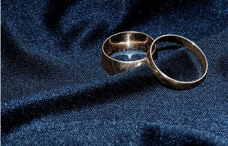 Two brilliant wedding rings on a black fabric.の写真素材