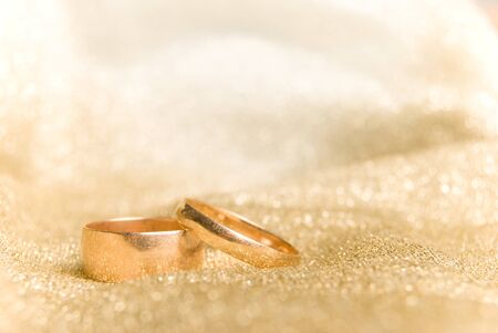Wedding rings, on a golden fabric backgroundの写真素材