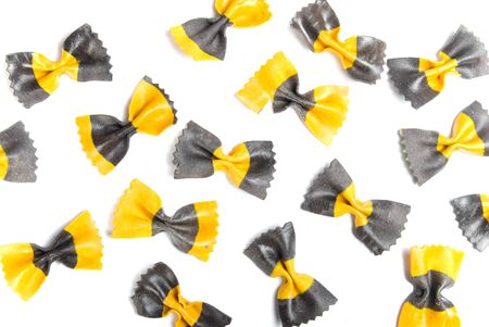 The yellow and black pasta is isolated on a white backgroundの写真素材