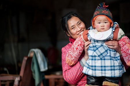 SICHUAN,CHINA-JANUARY 24,2010:Elderly holding grandson, her house is about to be removed and relocated due to urban renewal, she will be forced to move, January 24, 2010, Chengdu, Chinaのeditorial素材