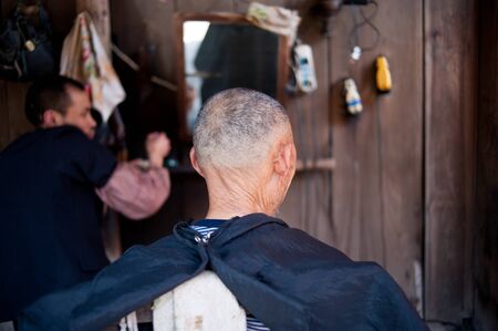 CHENGDU,CHINA-APRIL 24, 2011:unknown disability barber Barber for the guests, locals like to go here for a haircut, we are willing to help him, April 24, 2011のeditorial素材