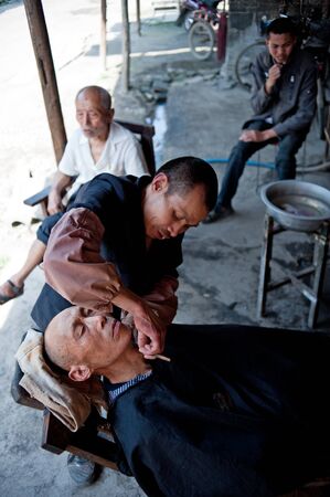 CHENGDU,CHINA-APRIL 24, 2011:unknown disability barber Barber for the guests, locals like to go here for a haircut, we are willing to help him, April 24, 2011のeditorial素材