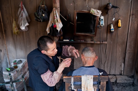 CHENGDU,CHINA-APRIL 24, 2011:unknown disability barber Barber for the guests, locals like to go here for a haircut, we are willing to help him, April 24, 2011のeditorial素材