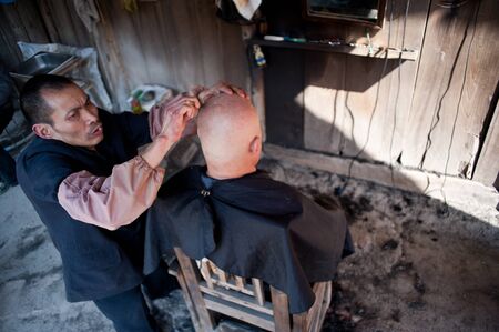 CHENGDU,CHINA-APRIL 24, 2011:unknown disability barber Barber for the guests, locals like to go here for a haircut, we are willing to help him, April 24, 2011のeditorial素材
