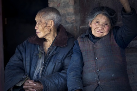 QIJIANG,SICHUAN, CHINA - APRIL 4, 2010:unnamed elderly sitting in the door of rest,April 4, 2010, Sichuan Province, China, Local elderly home alone unattended, children working in the field.のeditorial素材
