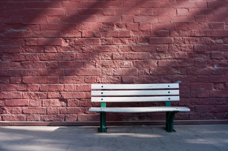 Red brick wall behind a bench の写真素材