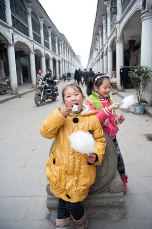 Sichuan, China -22 January, 2012, Girls eating cotton candy in the town, Sichuan, China, 2012 January 22,のeditorial素材