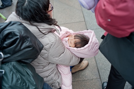 Chengdu, China-January 19, 2012, strange little girl in the railway station, the train back home, chengdu every year 20 million people take the train back home for the holiday  Chengdu, on January 19, 2012のeditorial素材