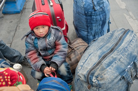 Chengdu, China-January 19, 2012, strange little girl in the railway station, the train back home,...