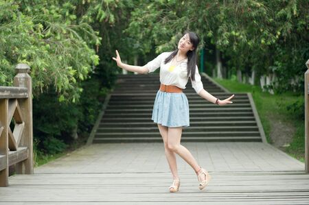 A young woman playing in the gardenの写真素材